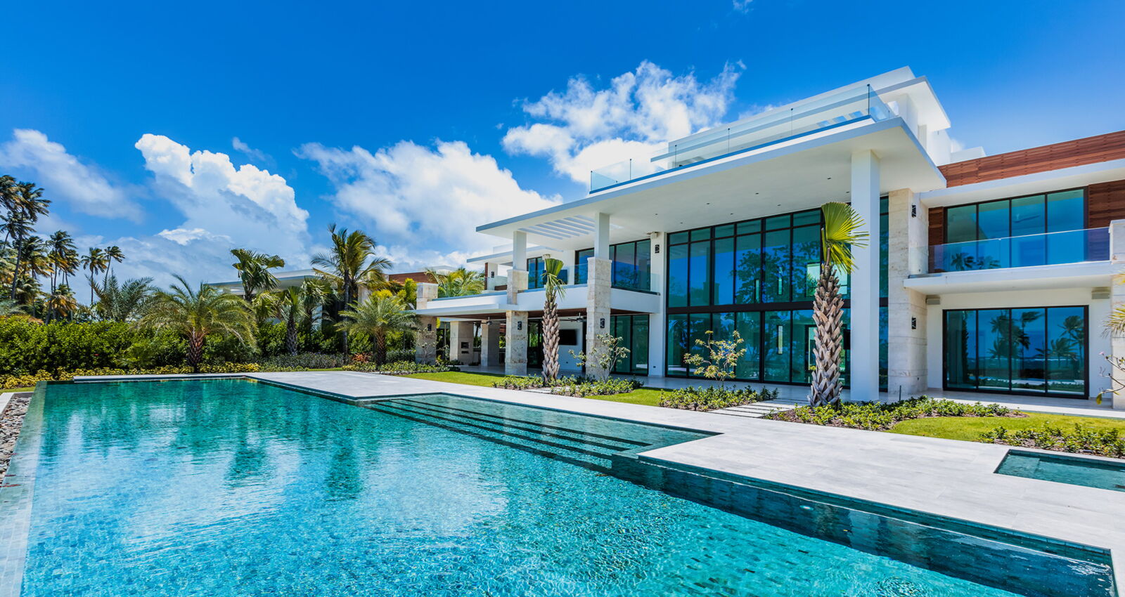 east beach estate for sale showcasing the pool and large windows